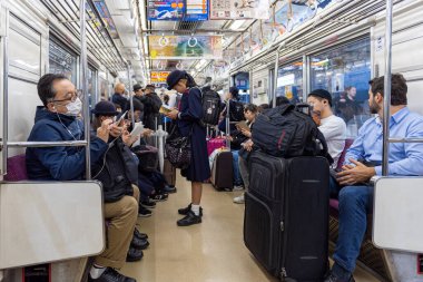 TOKYO, JAPAN - OCTOBER 24, 2019: Full People of Tokyo Train Car. People are traveling from airport to Tokyo City.  Keisei Main Line Rapid Limited Express