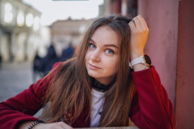 Litvanya 'nın Vilnius Eski Kasabası' ndaki Güzel Genç Kızın Yüzü 'nü kapatın. Kırmızı ceketli ve siyah pantolonlu. Güzel bir bahar günü. Meraklı Yüz