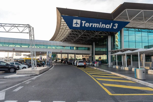 ROME, ITALY - OCTOBER 22, 2019: Rome international Leonardo da Vinci Fiumicino Airport exterior with cars. Departure area. Terminal 3 in Background