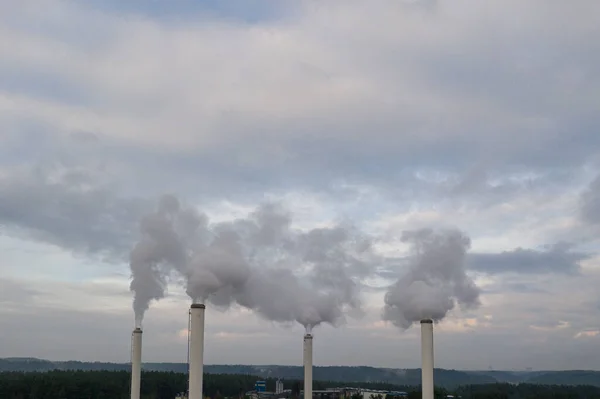 Smoking chimneys on the late autumn sky background. Heating season. The view of chimneys tops of the thermal station.