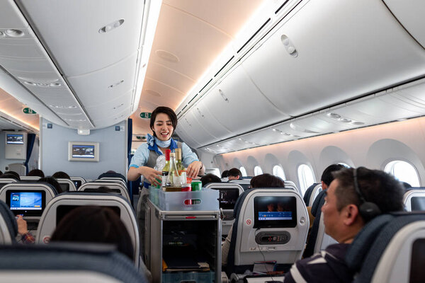 Japan ANA Airlines and Boeing 787 Dreamliner interior with People And ANA Cabin Crew Members working for passengers.