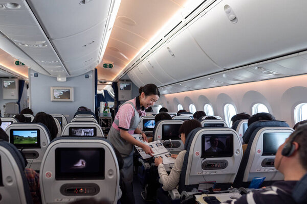 Japan ANA Airlines and Boeing 787 Dreamliner interior with People And ANA Cabin Crew Members working for passengers.