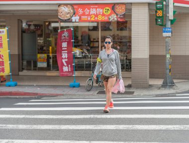 Taipei Street in one of suburb, district. Girl is Crossing the street.