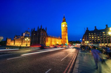 Londra Büyük Ben ve Westminster Köprüsü ile Westminster Sarayı. Uzun pozlama yüzünden bulanık insanlar. Hareket halindeki kırmızı otobüs