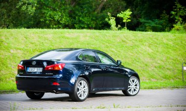 VILNIUS, LITHUANIA - 10 Temmuz 2012 Lüks Lexus Car. Yeşil Çim ve Park arka planda. Gündüz vakti. Güneş ışığı.