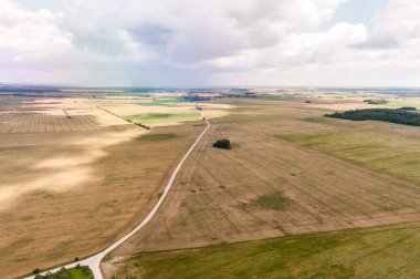 Litvanya 'da manzara ve doğa. Buğday tarlası ve çakıl yolu. Kuş Görünümü.