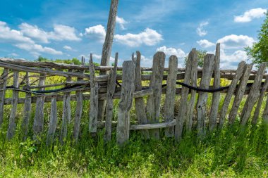 Kırsal bölgedeki eski ahşap çit. Yeşil Çimen ve Mavi Gökyüzü