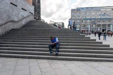 COLOGNE, Almanya - 25 Eylül 2015 Köln Katedrali, Almanya. Merdivenlerde Uyuyan Kişi.