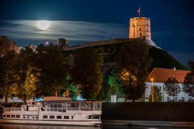 VILNIUS, Litvanya - 07 AĞUSTOS 2017: Vilnius, Litvanya 'daki Gediminas Kalesi. Dolunay arka planda. Gece fotoğrafı, uzun pozlama..