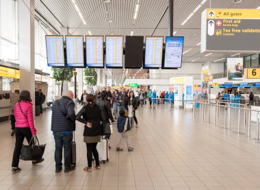 AMSTERDAM, NETHERLAND - 18 Ekim 2017: Uluslararası Amsterdam Havalimanı Schiphol İçişleri Yolcularıyla. Arkaplanda Ekranlar.