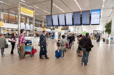 AMSTERDAM, NETHERLAND - 18 Ekim 2017: Uluslararası Amsterdam Havalimanı Schiphol İçişleri Yolcularıyla. İnsanlar ekrana bakıyor.