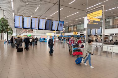 AMSTERDAM, NETHERLAND - 18 Ekim 2017: Uluslararası Amsterdam Havalimanı Schiphol İçişleri Yolcularıyla. Arkaplanda Ekranlar.
