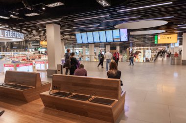 AMSTERDAM, NETHERLAND - 18 Ekim 2017: Uluslararası Amsterdam Havalimanı Schiphol İçişleri Yolcularıyla. Ekranlarla Ayrılış Alanı ve Gevşeme Alanı.
