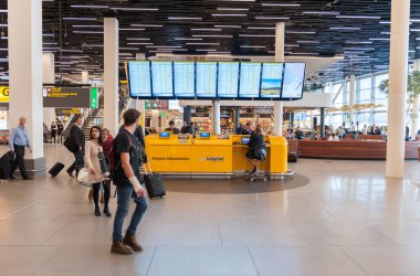 AMSTERDAM, NETHERLAND - 18 Ekim 2017: Uluslararası Amsterdam Havalimanı Schiphol İçişleri Yolcularıyla. Havaalanı Bilgi Masası ile Ayrılış Alanı