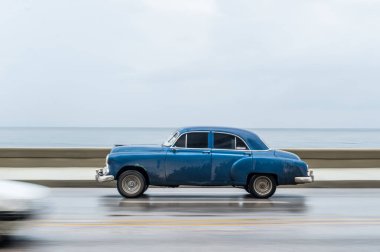 HAVANA, CUBA - 21 Ekim 2017: Havana, Küba 'daki eski araba. Pannnig. Retro Araç genellikle yerel halk ve turistler için bir taksi olarak kullanılır. Arka planda Karayip Denizi. Mavi Renk