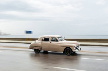 HAVANA, CUBA - 21 Ekim 2017: Havana, Küba 'daki eski araba. Pannnig. Retro Araç genellikle yerel halk ve turistler için bir taksi olarak kullanılır. Arka planda Karayip Denizi. Beyaz Renk