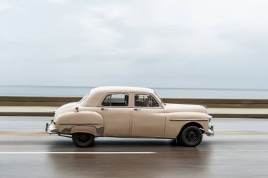 HAVANA, CUBA - 21 Ekim 2017: Havana, Küba 'daki eski araba. Pannnig. Retro Araç genellikle yerel halk ve turistler için bir taksi olarak kullanılır. Arka planda Karayip Denizi. Beyaz Renk