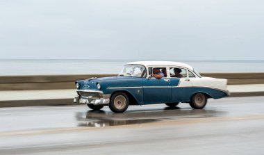 HAVANA, CUBA - 21 Ekim 2017: Havana, Küba 'daki eski araba. Pannnig. Retro Araç genellikle yerel halk ve turistler için bir taksi olarak kullanılır. Arka planda Karayip Denizi. Mavi Renk
