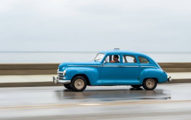 HAVANA, CUBA - 21 Ekim 2017: Havana, Küba 'daki eski araba. Pannnig. Retro Araç genellikle yerel halk ve turistler için bir taksi olarak kullanılır. Arka planda Karayip Denizi. Mavi Renk