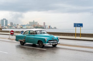HAVANA, CUBA - 21 Ekim 2017: Havana, Küba 'daki eski araba. Retro Araç genellikle yerel halk ve turistler için bir taksi olarak kullanılır. Arka planda Karayip Denizi. Mavi Renk