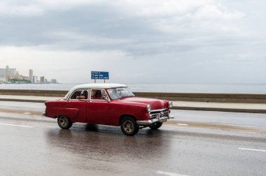 HAVANA, CUBA - 21 Ekim 2017: Havana, Küba 'daki eski araba. Retro Araç genellikle yerel halk ve turistler için bir taksi olarak kullanılır. Arka planda Karayip Denizi. Kırmızı Renk