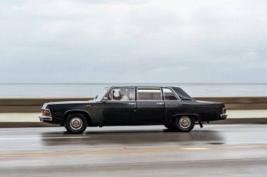 HAVANA, CUBA - 21 Ekim 2017: Havana, Küba 'daki eski araba. Retro Araç genellikle yerel halk ve turistler için bir taksi olarak kullanılır. Arka planda Karayip Denizi. Panning Siyah Renkli Araba