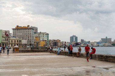 HAVANA, CUBA - 21 Ekim 2017 Havana, Küba 'da Malecon Caddesi. Karayip Denizi 'nde insanlar yürüyor ve balık tutuyor.