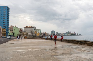 HAVANA, CUBA - 21 Ekim 2017 Havana, Küba 'da Malecon Caddesi. Karayip Denizi 'nde insanlar yürüyor ve balık tutuyor.