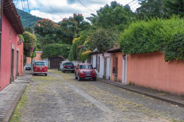 ANTIGUA, GUATEMALA - 11 Kasım 2017: Antigua, Guatemala şehri. Antigua, Güney Guatemala 'da volkanlarla çevrili küçük bir şehirdir. Arka planda Ağaçlar olan Güzel Sokak