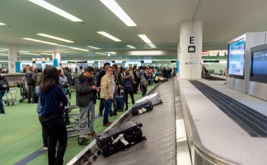 TOKYO, JAPONYAN - 9 Kasım 2018 Haneda Uluslararası Havaalanı Tokyo. Bagaj kemeri, bagaj atlıkarınca. İnsanlar bavullarını bekliyor..