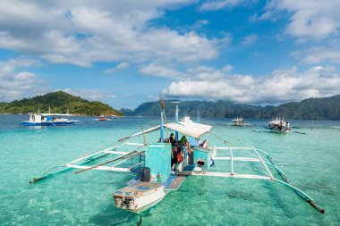 CORON, FİLİPPİNLER - 30 HAZİRAN 2018: tekneler turistleri bekliyor. CYC adası ve arka plandaki plaj. Koron, Filipinler.