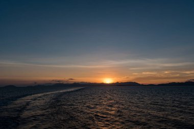 Gün batımı zamanı. Filipinler 'de okyanus ve arka planda dağlar. Peyzaj fotoğrafı.