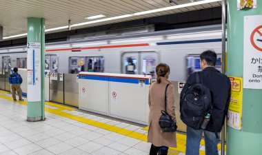 TOKYO, JAPONYA 17 Şubat 2018 Tokyo metrosu ve insanlar yaklaşan treni bekliyor..