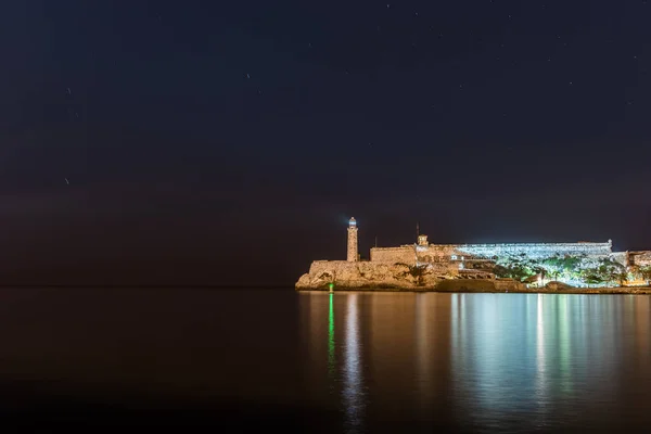 stock image Lighthouse Located in Havana, Cuba. Faro Castillo del Morro name. In Front of Caribbean Sea. Morro Castle in Background. Long Exposure Night Photography with Panning Stars.