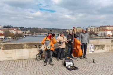 PRAG, CZECH - 11 Mart 2016: Çek Cumhuriyeti 'nin Prag kentindeki Vltave Nehri' nin karşısındaki Charles Köprüsü üzerinde Yerel Müzisyenler.