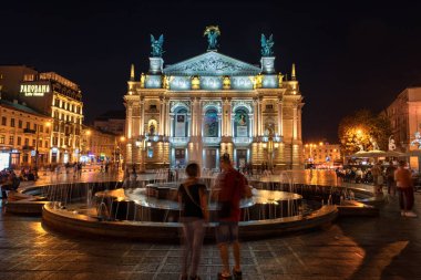 LVIV, UKRAINE - EPTEMBER 08, 2016: Lviv Ulusal Opera ve bale Akademik Tiyatrosu Solomiya Krushelnytska 'nın adını aldı. Uzun pozlama. Fountain 'in gece fotoğraf çekimi. Bulanık İnsanlar.