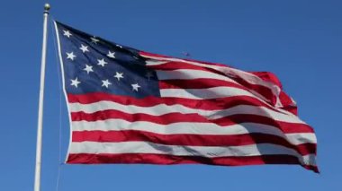 Clear Blue Sky 'da ABD Bayrağı sallıyor. Arka plandaki uçak. Amerikan Bayrağı. Amerika Birleşik Devletleri 'nin Meşhur Bayrağı' nı sallıyor. Güneşli Gün