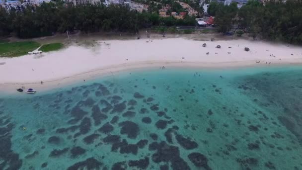 モーリシャス島のフリック フラクビーチ インド洋沿岸 地元の人々や観光客が砂の上に横たわっている 雲の多い空と山を背景に — ストック動画