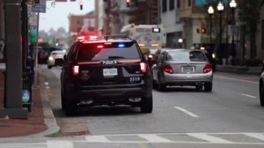 Baltimore Şehri Caddesi ve Polis Araç Işıkları. Toplu taşıma otobüsü trafiği ve arka plandaki insanlar. Maryland Eyaleti