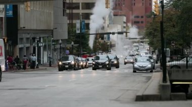 Baltimore City Caddesi ve Buhar Boruları 'nda trafik vardı. Arka plandaki otoparktan çıkan arabalar vardı. Maryland Eyaleti