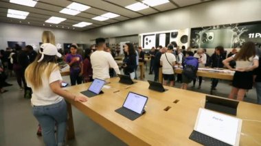 Philadelphia 'daki Apple Store' da insanlar Apple ürünlerini Menajerlerle inceliyor.