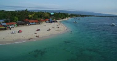 Moalboal, Cebu, Filipinler 'de White Beach ve Sahil. Seashore ve Arkaplanda İnsanlar 'la güzel bir manzara. 4k İHA