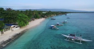 Moalboal, Cebu, Filipinler 'de White Beach ve Sahil. Seashore ve Arkaplanda İnsanlar 'la güzel bir manzara. 4k İHA