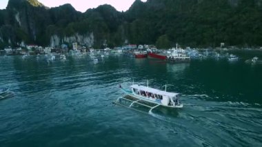 Filipinler, Palawan 'daki El Nido Plajı. Akşam Kumsalı, Tekne Turdan Dönüyor. Arka plandaki liman. Turistler arasında çok popüler bir gezi yeri. İHA