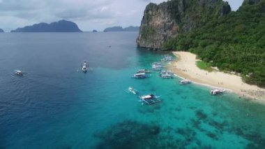 Helikopter Adası ve Palawan 'daki Plaj, Manzaralı Yer. El Nido, Filipinler 'de C turu. Berrak turkuaz suyu olan sakin, beyaz kumlu plaj, arka planda palmiye ağaçları, kaya oluşumları. İHA