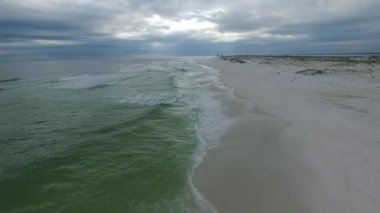Arka planda boş Pensacola Sahili ve Denizi. Florida mı? Meksika Körfezi. Arka planda iki kişi. İHA