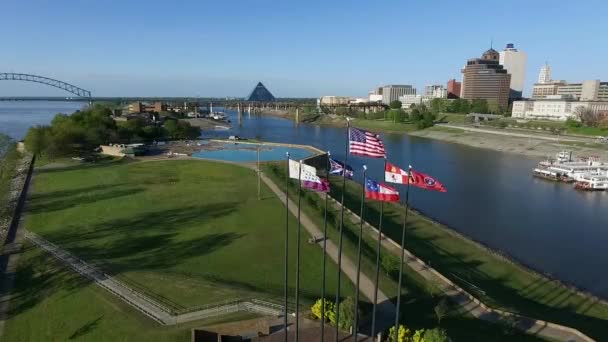 テネシー州メンフィスのマッド島川公園で旗を振る 背景にはヘルナンド ソト橋とミシシッピ川がある ドローン — ストック動画