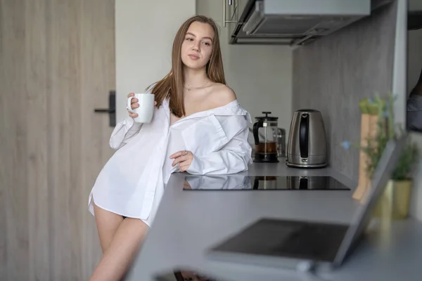 미녀는 부엌에 커피를 마시고 셔츠를 Burry Laptop Mobile Phone Desk — 스톡 사진