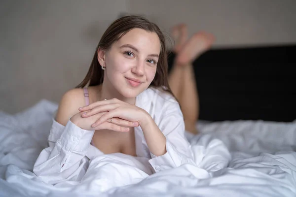 Gyönyörű Fiatal Lány Fekszik Ágyon Hálószobában Fehér Inget Visel Portré — Stock Fotó