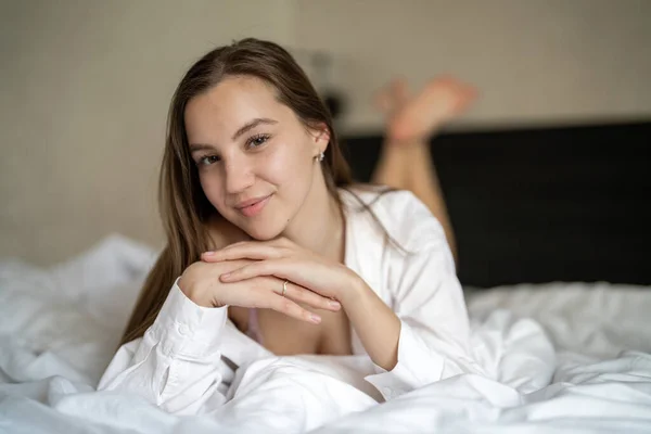 Gyönyörű Fiatal Lány Fekszik Ágyon Hálószobában Fehér Inget Visel Portré — Stock Fotó